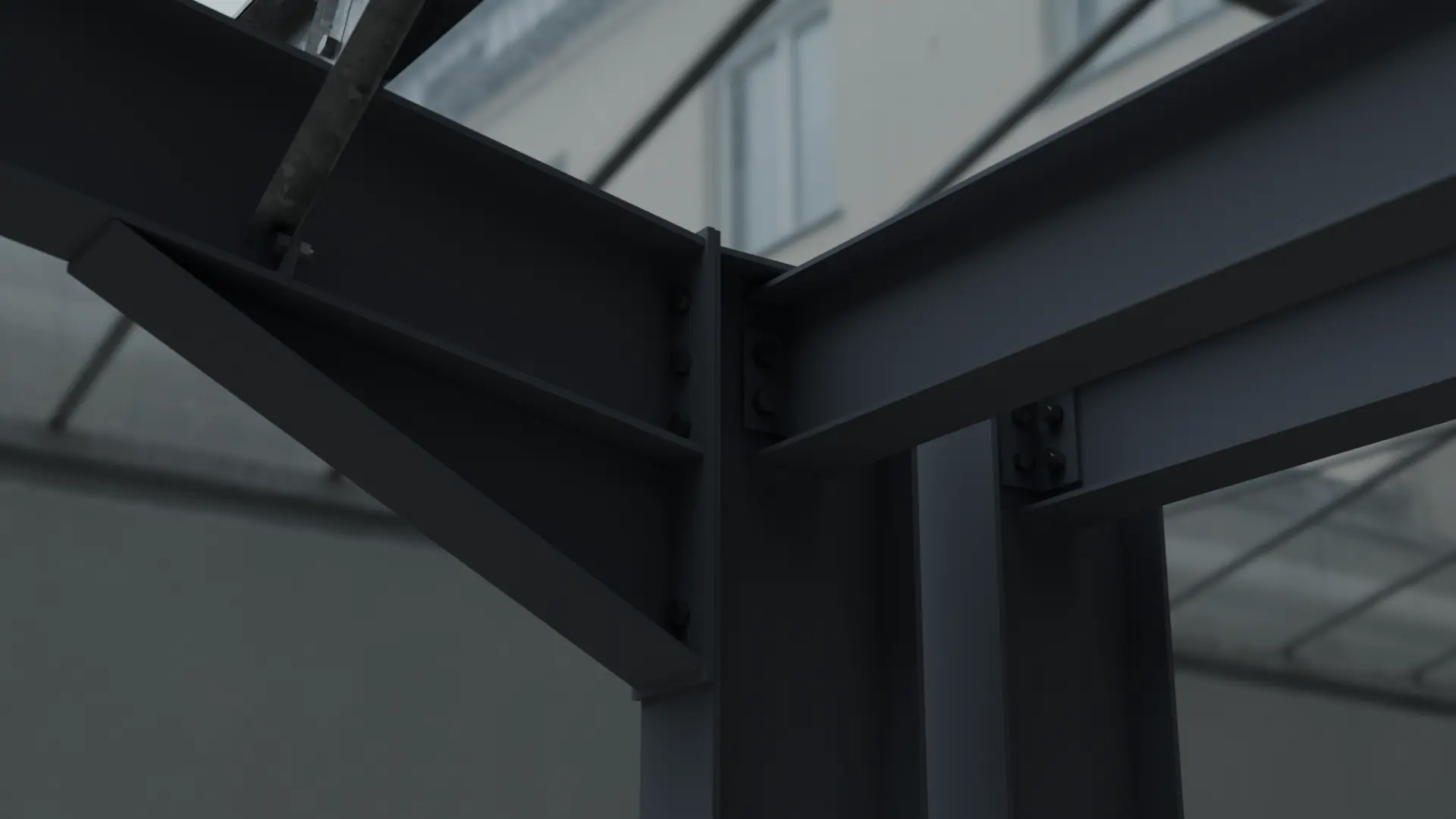 Dark grey bolted knee connection under a glazed roof