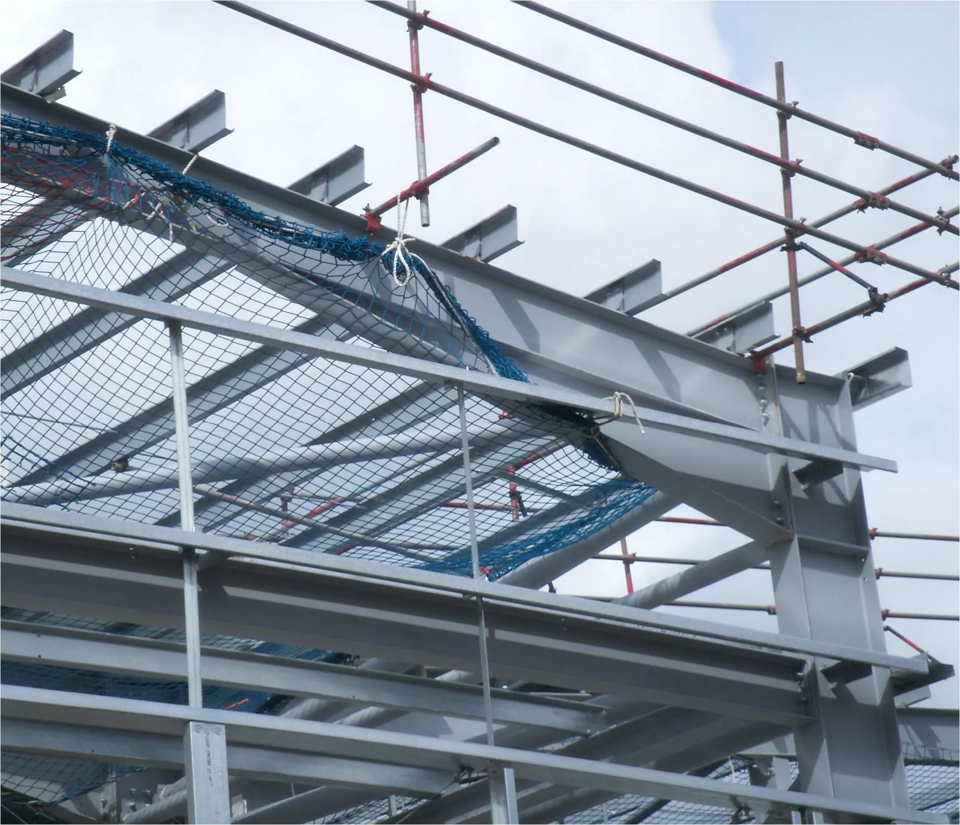 Steel frame mid-erection with safety netting and scaffold